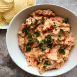 Pimento cheese spread with potato chips in background.