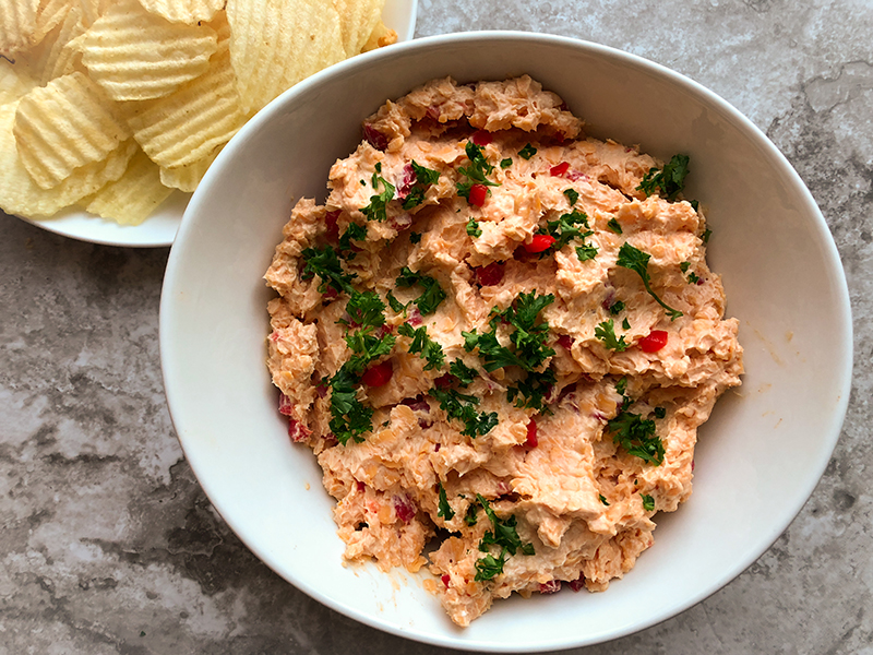 Pimento cheese spread with potato chips in background.
